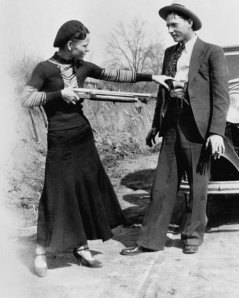 Bonnie playfully pointing a rifle at Clyde