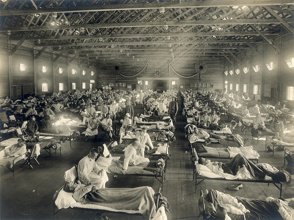 Black and white photo of Camp Funston during Spanish flu featuring room full of patients on cots