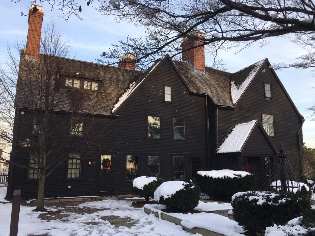Exterior of a large dark-colored house with snow