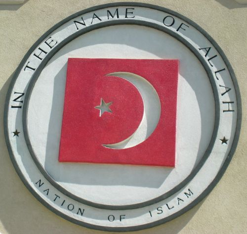 Photo of a round logo featuring a crescent moon and star against a red background, and reading: In the Name of Allah: Nation of Islam